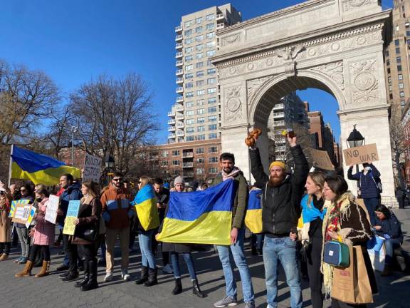 Demonstrators hold Ukrainian flags and signs reading “Stop the War.”