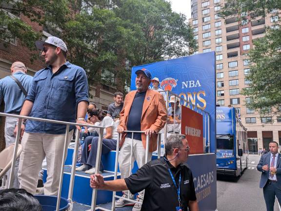 Knicks owner James Dolan in orange jacket quietly awaits the start of Knicks parade.
