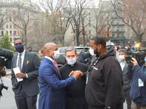 Mayor Eric Adams greets cook Robert Finn, Thomas Perry’s colleague, on Sunday, Jan. 2, 2021 outside the Cathedral of St. John the Divine. Photo: Lydell Tyson