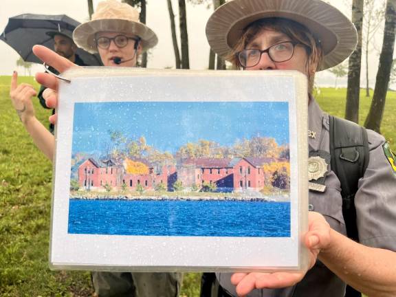 Park Ranger Todaro displays an image of what one of the Hart Island buildings looked like before they were torn down in 2022, when the Parks Department over the island from Department of Corrections.