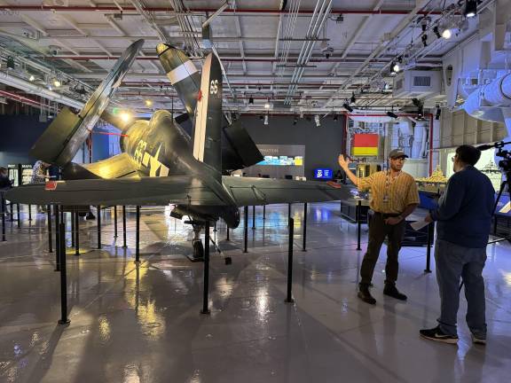 Peter Torraca, right, in yellow, was in charge of restoring the Corsair. Being able to work on the aircraft has Torraca and his staff feeling “hugely honored.”