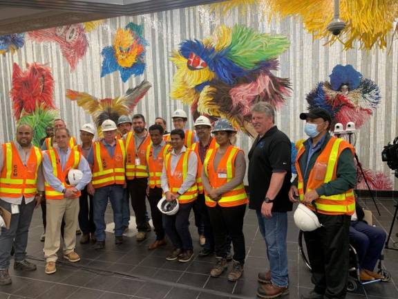 Construction workers who helped with the opening of the new entrance at Times Square Subway Station pause against the Nick Cave mural, part of the revitalization of the station. Photo: Ralph Spielman