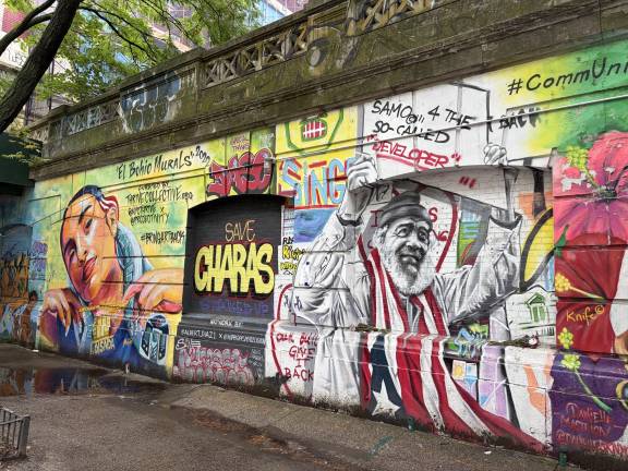 Carlos “Chino” Garcia draped in Puerto Rican flag on a mural at P.S. 64 / Charas on East 10th Street.