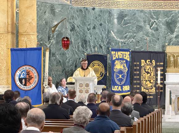 Union banners adorn the altar behind Father Brian Jordan during a mass dedicated to the construction workers who died during the 9/11 terror attack and the many thousands who worked on clearing the rubble for eight months afterward. Many of those workers also subsequently died of 9/11-related diseases.