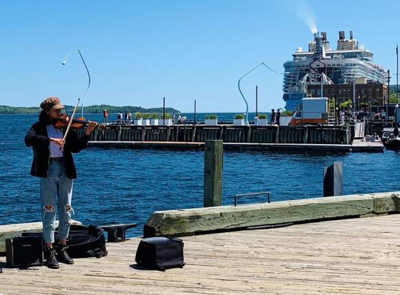 The two-and-a-half mile boardwalk in Halifax makes it easy to visit Downtown from the piers. Here, a fiddler, a strong Nova Scotia tradition, plays against the backdrop of The Oasis of the Seas. Photo: Ralph Spielman