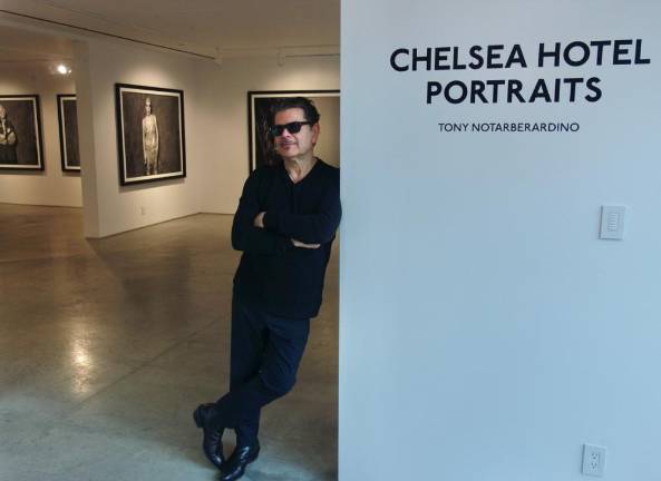 Photographer Tony Noterbaradino rests against sign at the opening of his show that captured the artists, writers and zany characters who once resided in the Chelsea Hotel. The show opened March 10 at the ACA Gallery on Tenth Ave. and runs through April 13. Photo: Deborah Fenker