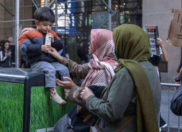 A young boy drinks from a juice box at the Oct. 13 pro-Palestine rally.