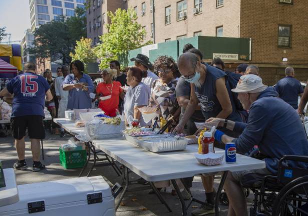Attendees at the National Night Out Against Crime at the Fulton Houses getting BBQ food. This event was staged by the 10th Precinct as part of the 43rd citywide and national celebration.