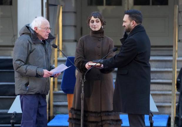 Senator Bernie Sanders Swears in Mayor Zohran Mamdani in a City Hall ceremony on Jan. 1 as his wife, Rama Duwaji holds the Quran.