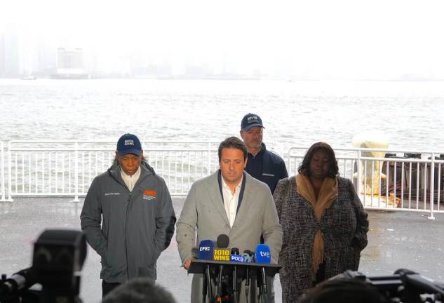 ”Our hearts are broken,” Eric Adams (left) said after escorting Joan Camprubi Montal (center) and other grieving family members to the spot on the Hudson River where six people died in a helicopter crash.