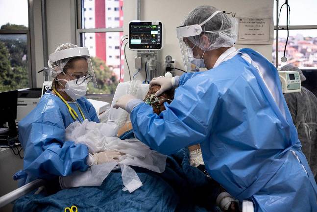 Medical professionals treat a COVID-19 patient in an intensive care unit.