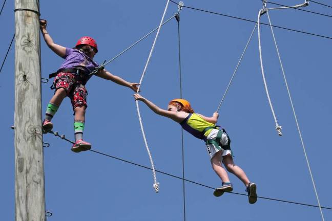 Campers on a rope course at Piperwood Camp, run by the Girl Scouts of Western NY. Photo: Camp Piperwood via American Camp Association of NY and NJ