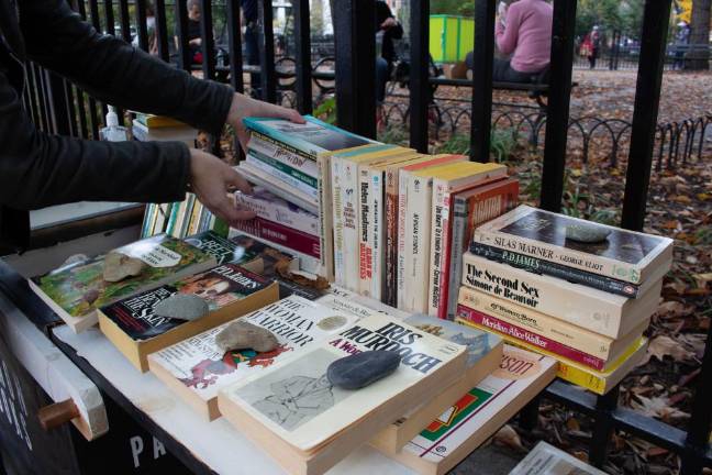 Bond places stones on the books to keep them from being blown away. Photo: James Pothen