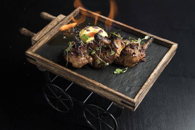 Flaming chicken chops served on a cart. Photo: Evan Sung