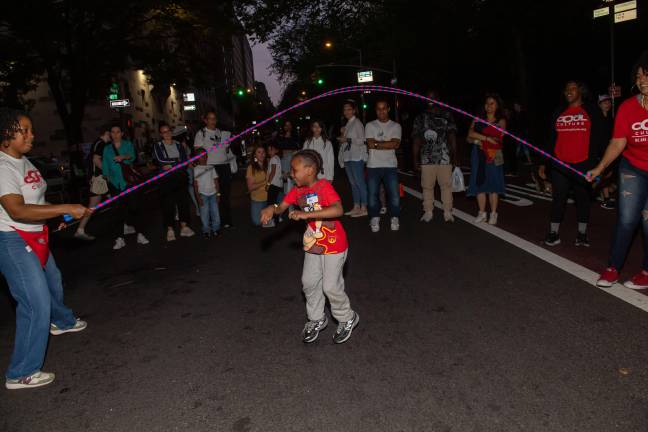Young festivalgoer jumps rope with volunteers for Cool Culture.