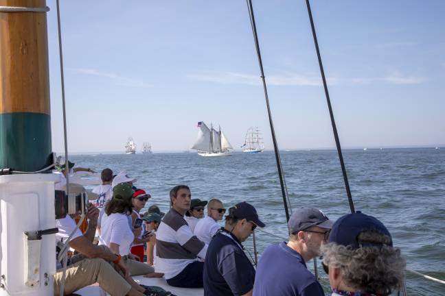 Passengers onboard the Adirondack watching the sights of international aircraft and ships.