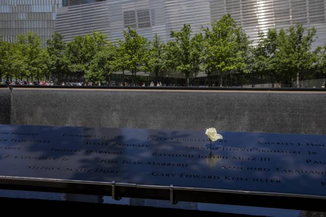 A white rose placed on the periphery of the memorial. After attending the press conference, Straus News observed the 9/11 Memorial Pools in World Trade Center. The two reflecting pools encompass/physicalize the immeasurable loss from the terrorist attack that continues to take lives today.