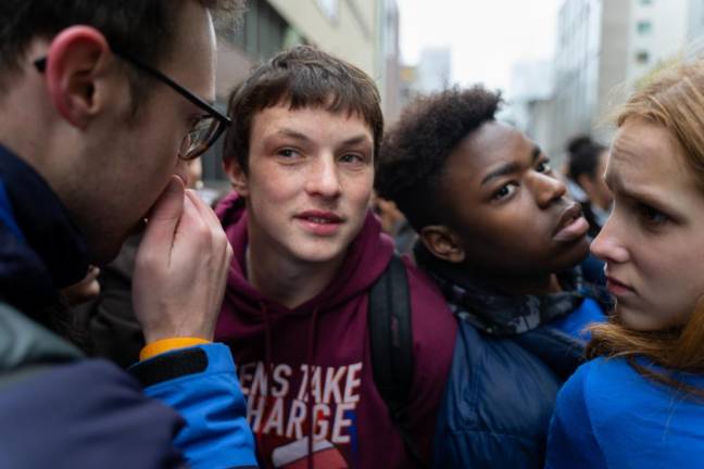 From left to right: Taylor McGraw (an adult advisor for Teens Take Charge), Beacon student leader Toby Paperno with Marcus Alston and Cameron Leo discussing plans for the rest of the walkout. Paperno, Alston, and Leo all spoke during the strike.