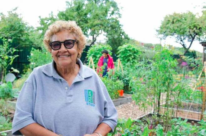 Jenny Benitez in front of garden boxes.