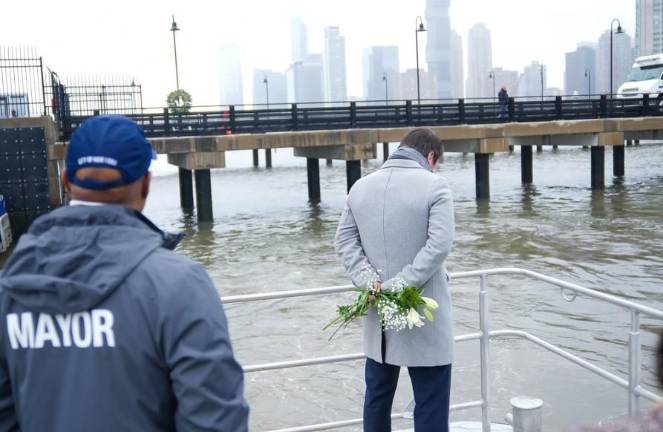 A heartbroken Joan Camprubí Montal (right) reflects before tossing flowers into the Hudson River near the site where his sister Mercè Camprubi Montal died along with her husband and their three children.