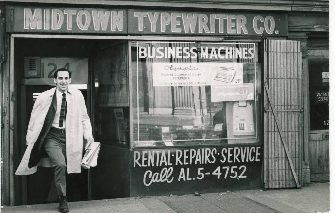 Harmon Rangell walking out of his former shop in Chelsea in the 1960s. The reflection in the window is of the facade of St. Vincent de Paul church directly across the street. Photo courtesy of Harmon Rangell