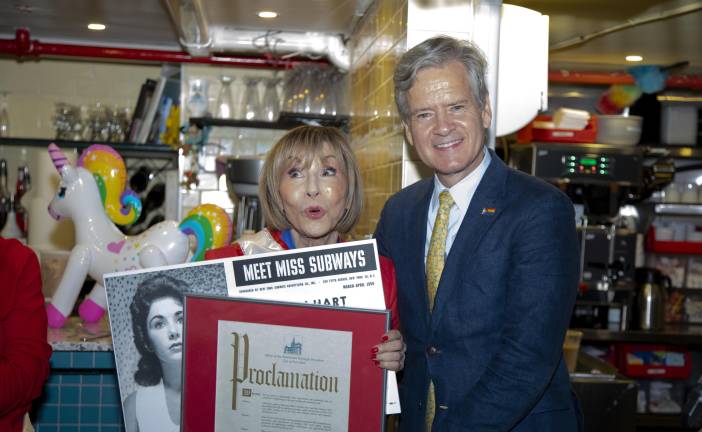 Ellen Hart, owner of Ellen’s Stardust Diner and a former Miss Subways (1959), poses with Manhattan Borough President Brad Hoylman-Sigal holding her original Miss Subways poster and a Proclamation in celebration of the Miss Subways reunion and her 85th birthday.