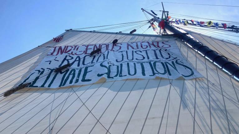 The sail’s starboard side reads, “Indigenous Rights, Racial Justice, Climate Solutions.”