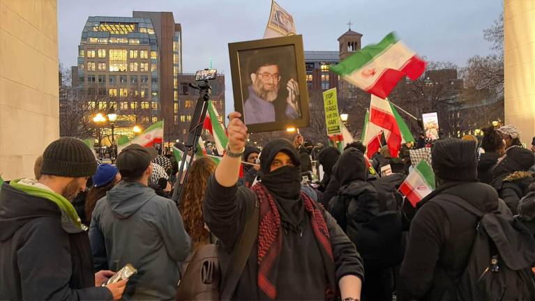 A vigil attendee holds up a framed photo of a young Ayatollah Khamenei.