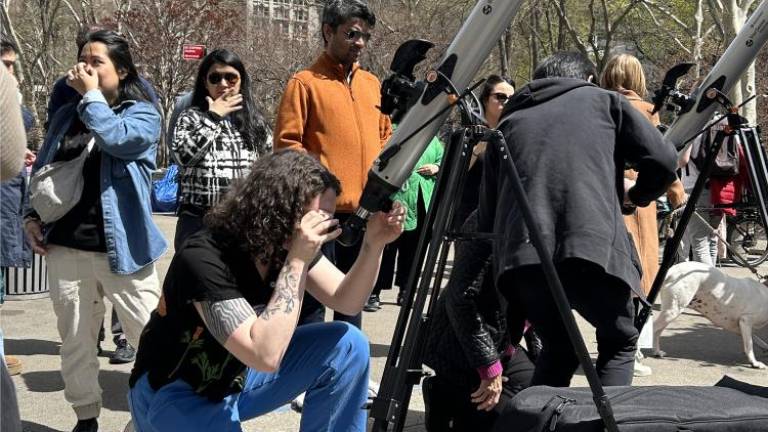 Dee Graham, a scientist looking through a telescope from the Science Foundation Flatiron Institute on Broadway and E 23rd Street in Flatiron on April 8. Photo Credit: Alessia Girardin.