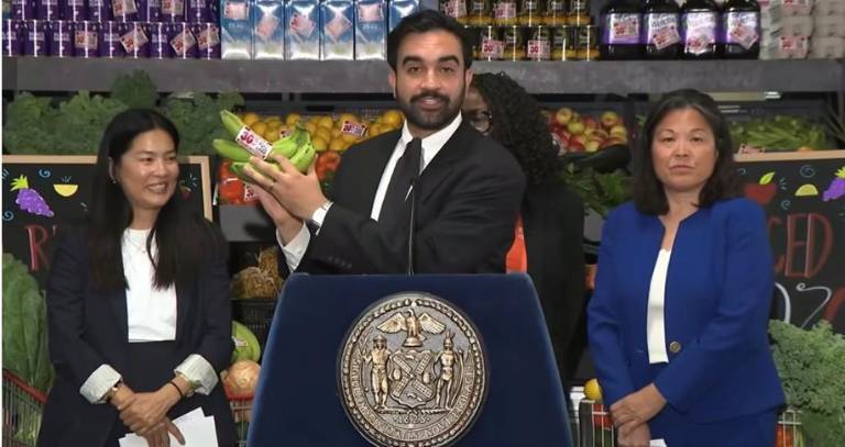 Mayor Zohran Mamdani holding a pair of plantains at a press conference on July 27 regarding city-owned grocery stores.