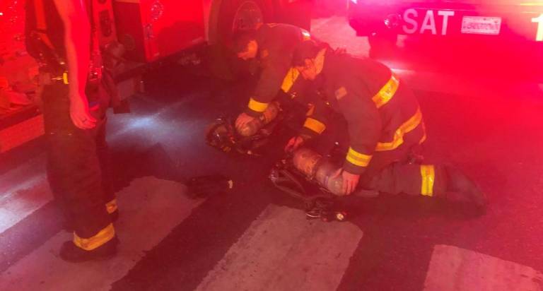 <b>One firefighter was taken to Bellevue Hospital after battling blaze on W. 35th St. on April 14. Firefighters pack up oxygen tanks after two alarm fire was extinguished.</b> Photo: Keith J. Kelly