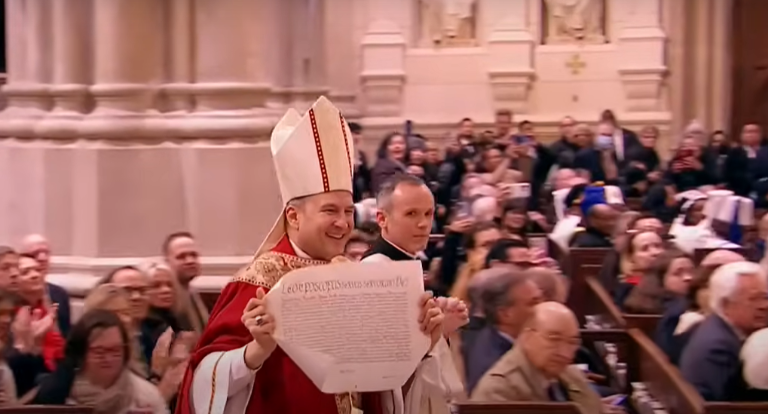 Archbishop displays the apostolic letter from Pope Leo appointing him the new archbishop of New York.