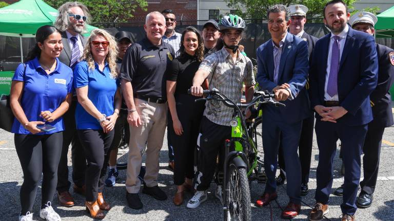 Commissioner Rodriguez, Commissioner Tucker, and others with a delivery worker receiving a fire-safe certified e-bike at the E-Bike Trade-In pilot program event.