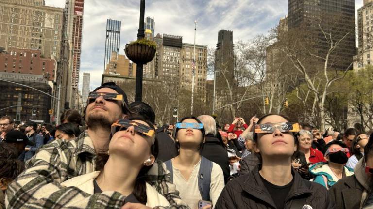 New Yorkers and foreigners looking up at the solar eclipse at 3:25 p.m. on Broadway and E 23rd Street in Flatiron. Photo Credit: Alessia Girardin.