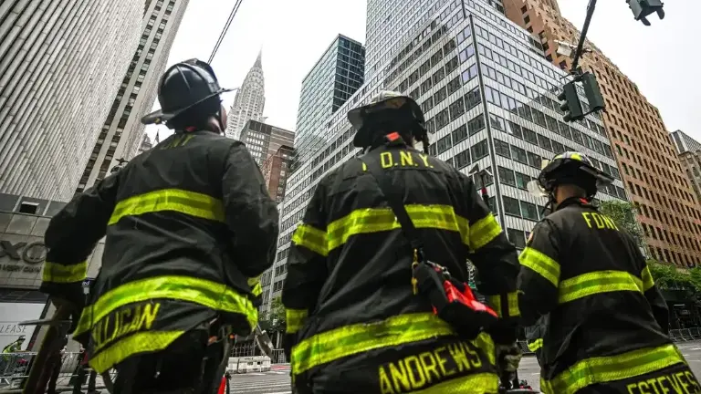 FDNY members wait outside the failing building.