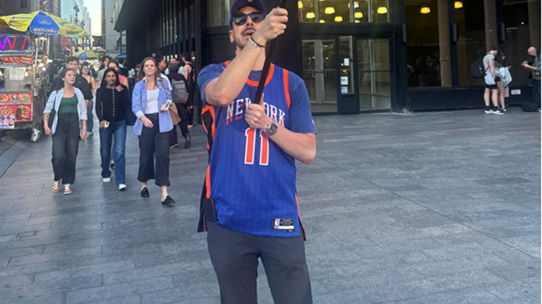 A fan waves a Knicks flag outside Madison Square Garden before the start of game 1.